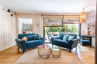 a living room with two blue couches and a table at Souviens-toit in Puget