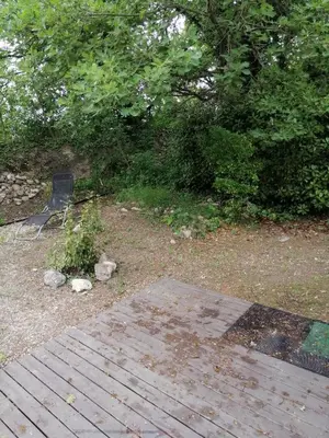 a garden with a wooden path and trees and bushes at mobil home chez ANIK & ALAIN in La Roque-dʼAnthéron