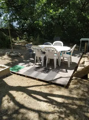 a white table and chairs sitting on a patio at mobil home chez ANIK & ALAIN in La Roque-dʼAnthéron