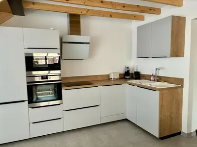 a kitchen with white cabinets and a sink at Maison rénovée 3 chambres in Mollégès