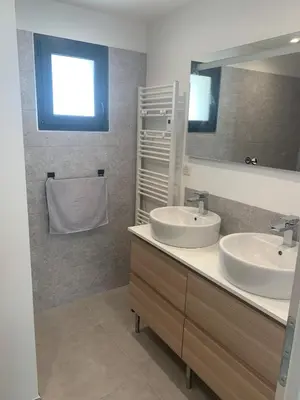 a bathroom with two sinks and a mirror at Maison rénovée 3 chambres in Mollégès