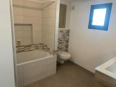 a bathroom with a tub and a toilet and a sink at Maison rénovée 3 chambres in Mollégès
