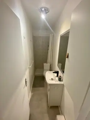 a white bathroom with a sink and a toilet at Studio Cosy in Pélissanne