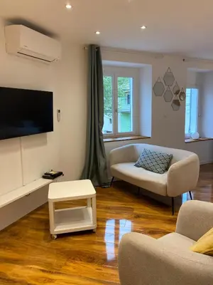 a living room with a couch and a tv at Studio Cosy in Pélissanne