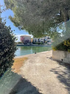 a river with two birds standing on the side of it at Appartement neuf avec vue in Mallemort