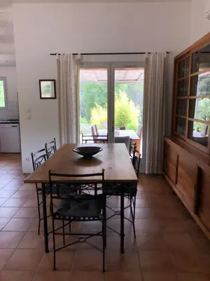 a dining room with a wooden table and chairs at Une maison en Provence piscine au pied du Luberon in Mérindol