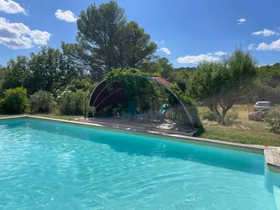 a swimming pool with a fountain in a yard at Une maison en Provence piscine au pied du Luberon in Mérindol