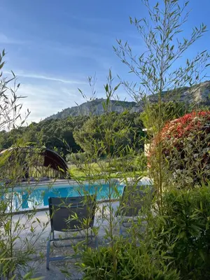 a table and chairs sitting next to a swimming pool at Une maison en Provence piscine au pied du Luberon in Mérindol