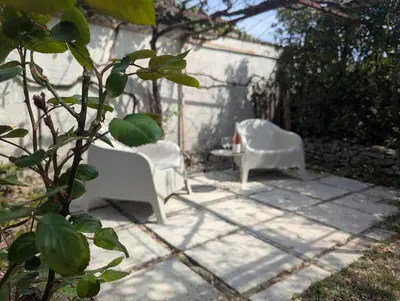 two white chairs and a table on a patio at La Bergerie de Lorette - Au Cœur du Luberon in Bonnieux