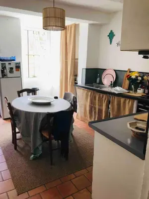 a kitchen with a table and a kitchen with a table and chairs at Lubéron Grde Maison de village avec terrasse 4 chambres doubles in Saint-Martin-de-Castillon