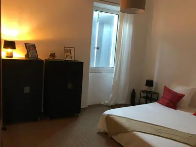 a bedroom with a bed and a window at Lubéron Grde Maison de village avec terrasse 4 chambres doubles in Saint-Martin-de-Castillon