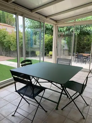 a ping pong table on a screened porch with chairs at 140 m2 villa with pool in Pernes-Les-Fontaines in Pernes-les-Fontaines