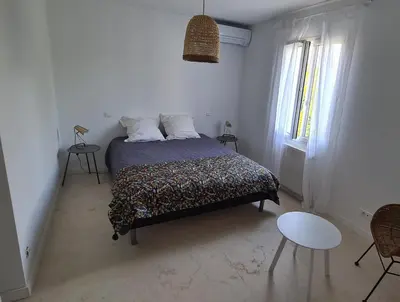 a bedroom with a bed in a white room at 140 m2 villa with pool in Pernes-Les-Fontaines in Pernes-les-Fontaines