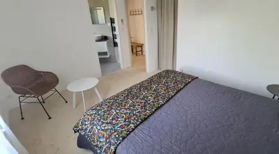 a bedroom with a bed and a chair and a table at 140 m2 villa with pool in Pernes-Les-Fontaines in Pernes-les-Fontaines