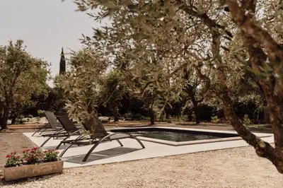 a group of chairs sitting next to a pool at La Villa Des Garrigues in Mazan