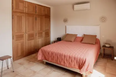 a bedroom with a large bed and wooden cabinets at La Villa Des Garrigues in Mazan