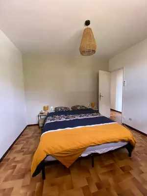 a bedroom with a large bed with a yellow blanket at Les Mourguettes maison familiale avec piscine et garage sur 2000 m2 de terrain en campagne in Carpentras