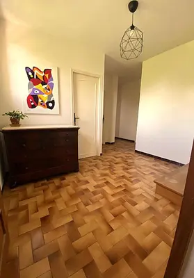a room with a wooden floor and a painting on the wall at Les Mourguettes maison familiale avec piscine et garage sur 2000 m2 de terrain en campagne in Carpentras