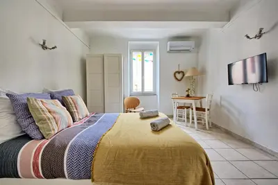 a bedroom with a bed and a table and a television at Studio Romarin in La Fare-les-Oliviers