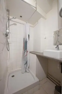 a white bathroom with a shower and a sink at Studio Romarin in La Fare-les-Oliviers