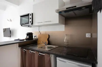 a small kitchen with a sink and a microwave at Studio Romarin in La Fare-les-Oliviers
