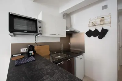 a small kitchen with a sink and a microwave at Studio Romarin in La Fare-les-Oliviers