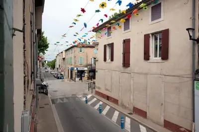 a city street with flags hanging from buildings at Studio Romarin in La Fare-les-Oliviers