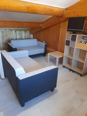 a living room with two beds and a tv at Chambres d'Hôtes Chez Cécile à Lagnes in Lagnes