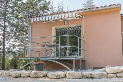 a house with a balcony with a table on it at La Luberonnette in Saint-Saturnin-les-Apt