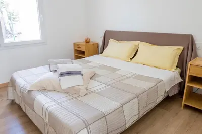 a bedroom with a bed with white sheets and yellow pillows at La Luberonnette in Saint-Saturnin-les-Apt