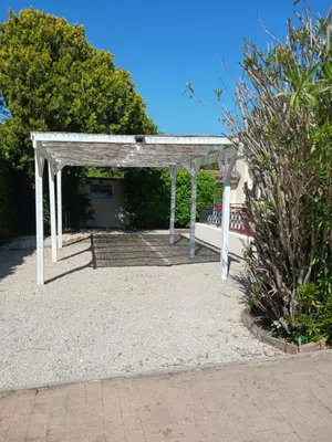 a white pergola on a sandy beach with trees at MAISON Terrasse PISCINE in Cavaillon