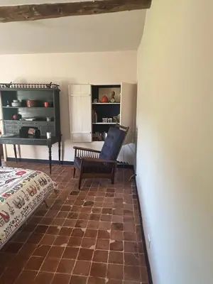 a room with a bed and a chair in a room at Silence et Reconnexion in Mormoiron
