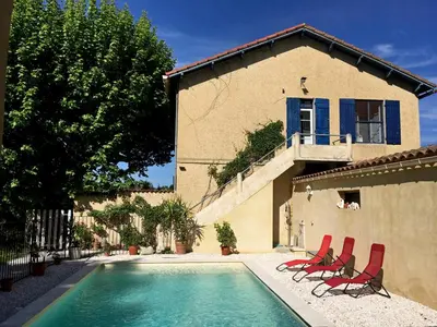a swimming pool with chairs and a house at Mas De La Pomme De Pin in Noves