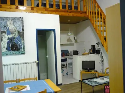 a living room with a staircase and a kitchen at Mas De La Pomme De Pin in Noves