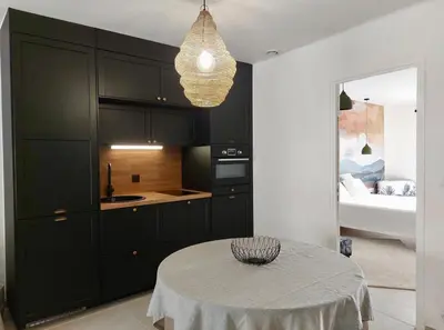 a kitchen with black cabinets and a table with a bowl on it at La maison de Flassan chic et sport in Flassan