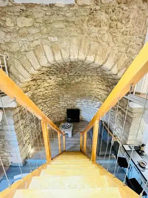 a stairway leading up to a building with a stone wall at Charme unique sous les remparts in Châteauneuf-de-Gadagne