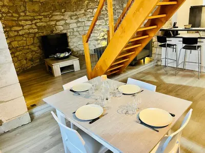 a table with white plates and wine glasses on it at Charme unique sous les remparts in Châteauneuf-de-Gadagne