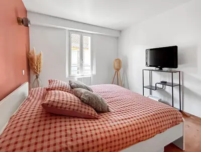 a bedroom with a bed with a red checkered blanket at Grand appartement spacieux et lumineux à Noves in Noves