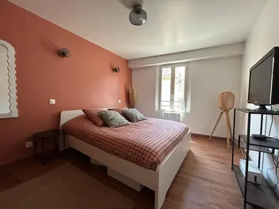a bedroom with a bed and a flat screen tv at Grand appartement spacieux et lumineux à Noves in Noves