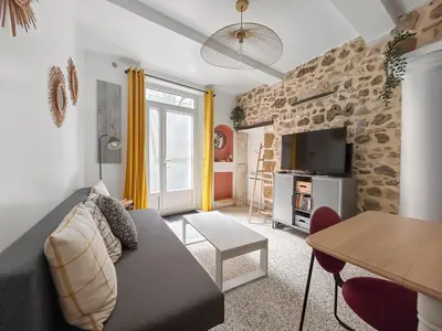 a living room with a couch and a stone wall at Grand appartement spacieux et lumineux à Noves in Noves
