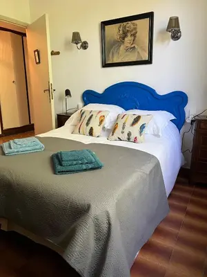 a bedroom with a large bed with a blue headboard at Escapade entre amis en Provence, 4 chambres, terrasse & jardin, proche Avignon in Caumont-sur-Durance