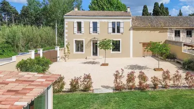 a large house with a courtyard in front of it at Le Champ des Cigales in Noves