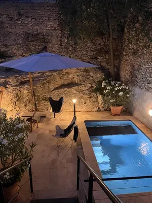 a swimming pool with an umbrella and a table and chairs at Maison de village en Provence Luberon in Saint-Saturnin-les-Apt