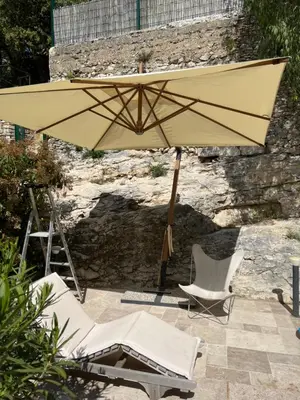 a yellow umbrella and two chairs and a table and chairs at Maison de village en Provence Luberon in Saint-Saturnin-les-Apt