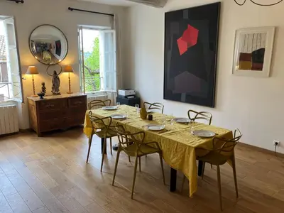 a dining room with a table with chairs and a painting at Maison de village en Provence Luberon in Saint-Saturnin-les-Apt