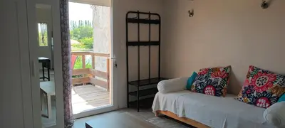 a living room with a couch and a sliding glass door at Nid douillet au cœur du Vaucluse in Entraigues-sur-la-Sorgue