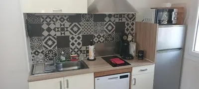 a small kitchen with a sink and a refrigerator at Nid douillet au cœur du Vaucluse in Entraigues-sur-la-Sorgue
