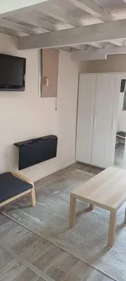 a room with a couch and a table and a tv at Nid douillet au cœur du Vaucluse in Entraigues-sur-la-Sorgue