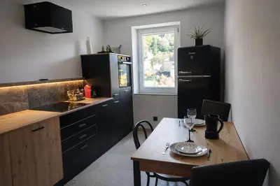 a kitchen with a wooden table and a small table with glasses on it at Maison privée billard spa dans village du Luberon in Cabrières-dʼAigues