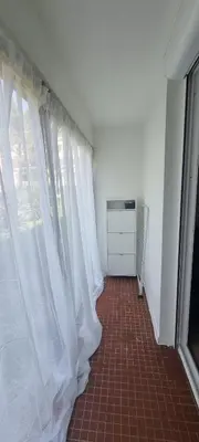 a hallway with white curtains and a red tile floor at Appartement in Aix-en-Provence